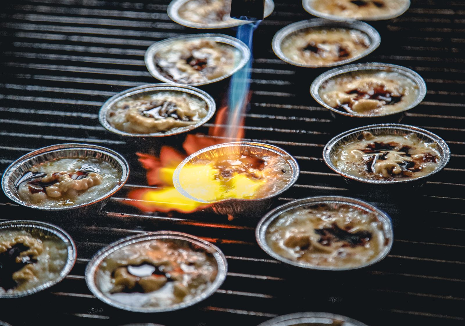Sunday Roast chef finishing scallops with a torch during an omakase BBQ service