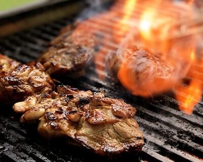 Sunday Roast BBQ chef cooking premium cuts on a live grill for a private event in Singapore.